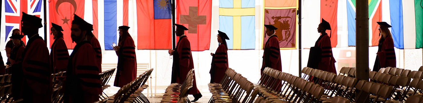 Graduates with flags in background