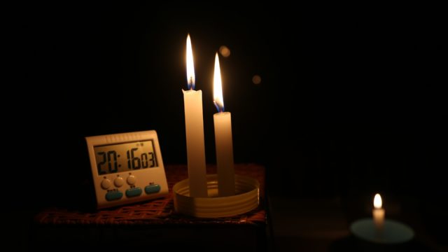 Candles and a clock in a dark room.