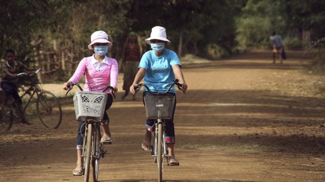 Two people on bikes in face masks