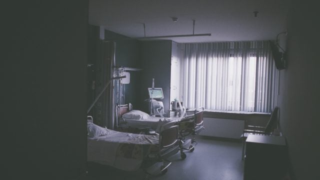 An empty hospital room with two beds.