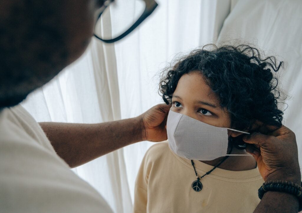 Man putting medical mask on a child