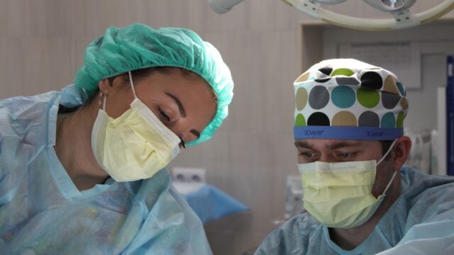 Two doctors wearing scrubs and masks