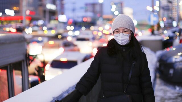 young woman wearing face mask in wintertime