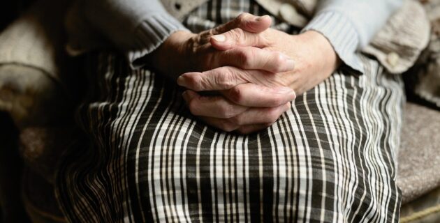 An elderly woman's hands folded in her lap