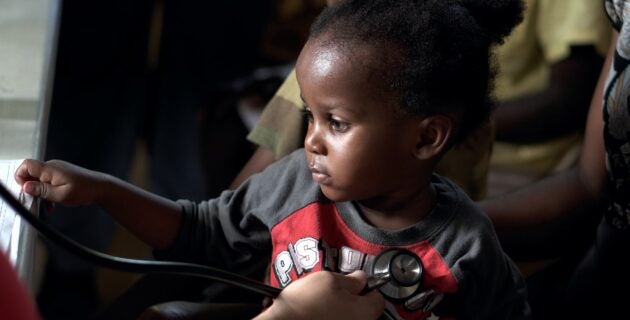 A doctor uses a stethescope on a small boy