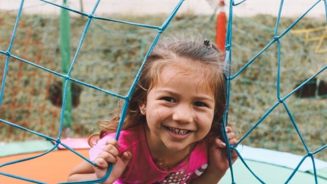 A young girl smiles on a playground