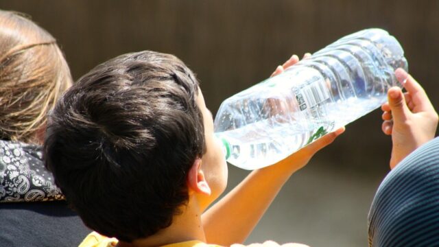 Boy drinking water on a hot day