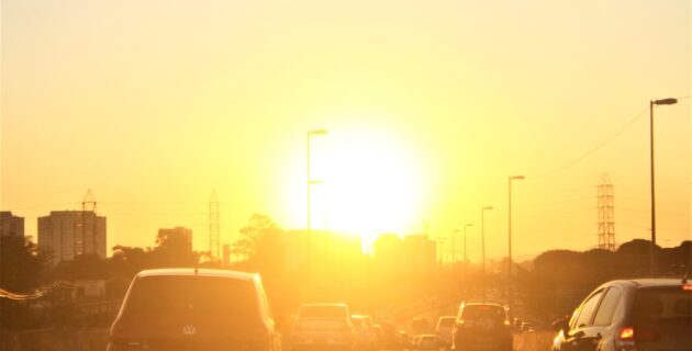 Highway traffic in front of a blazing sun