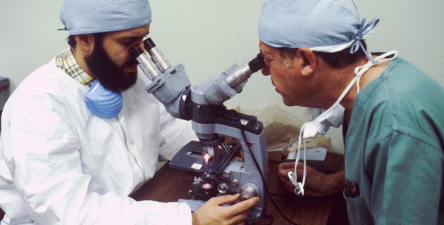 Two pathologists looking into microscope