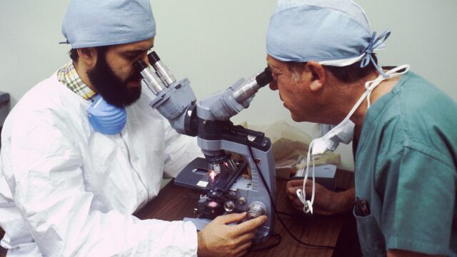 Two pathologists looking into microscope