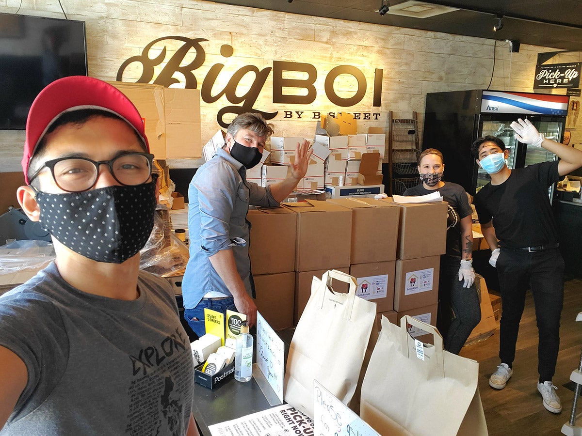 Photo of Antonio Moya with mask on delivering boxes