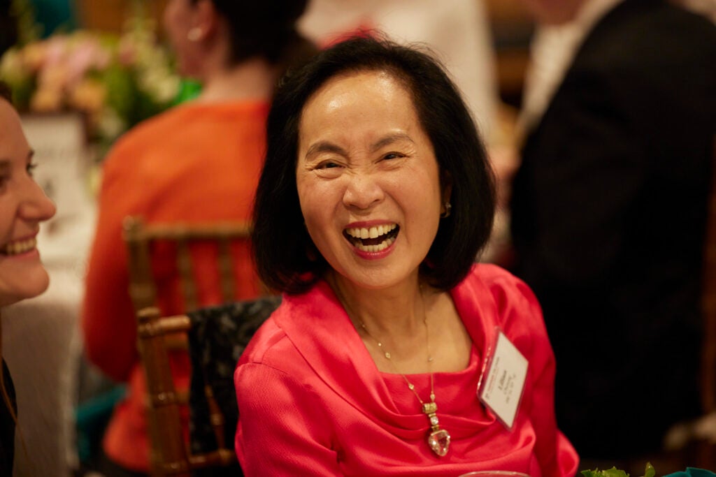 Lilian Cheung laughing, wearing a festive red outfit.