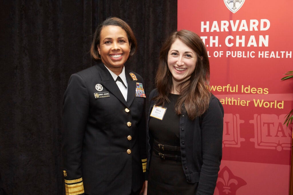 Rear Admiral Sylvia Trent-Adams and Aviva Musicus pose in front of a Harvard Chan School banner