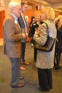 Full-length image of fellowship celebration guests chatting with Dean Baccarelli