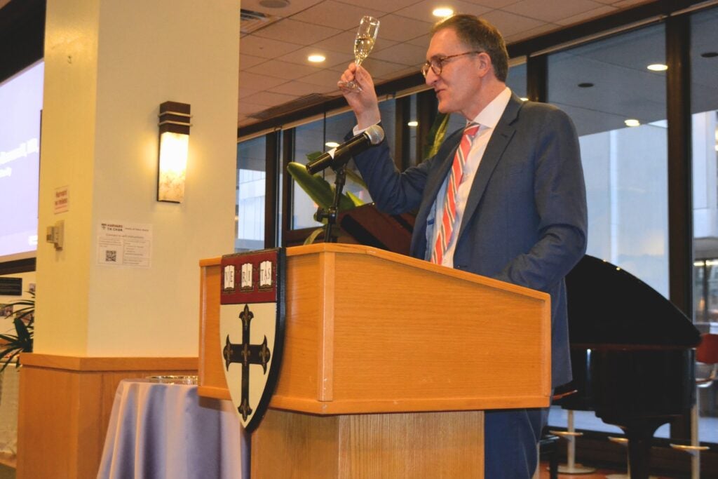 Dean Baccarelli ends his remarks with a toast at the podium