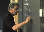 professor writing on chalkboard