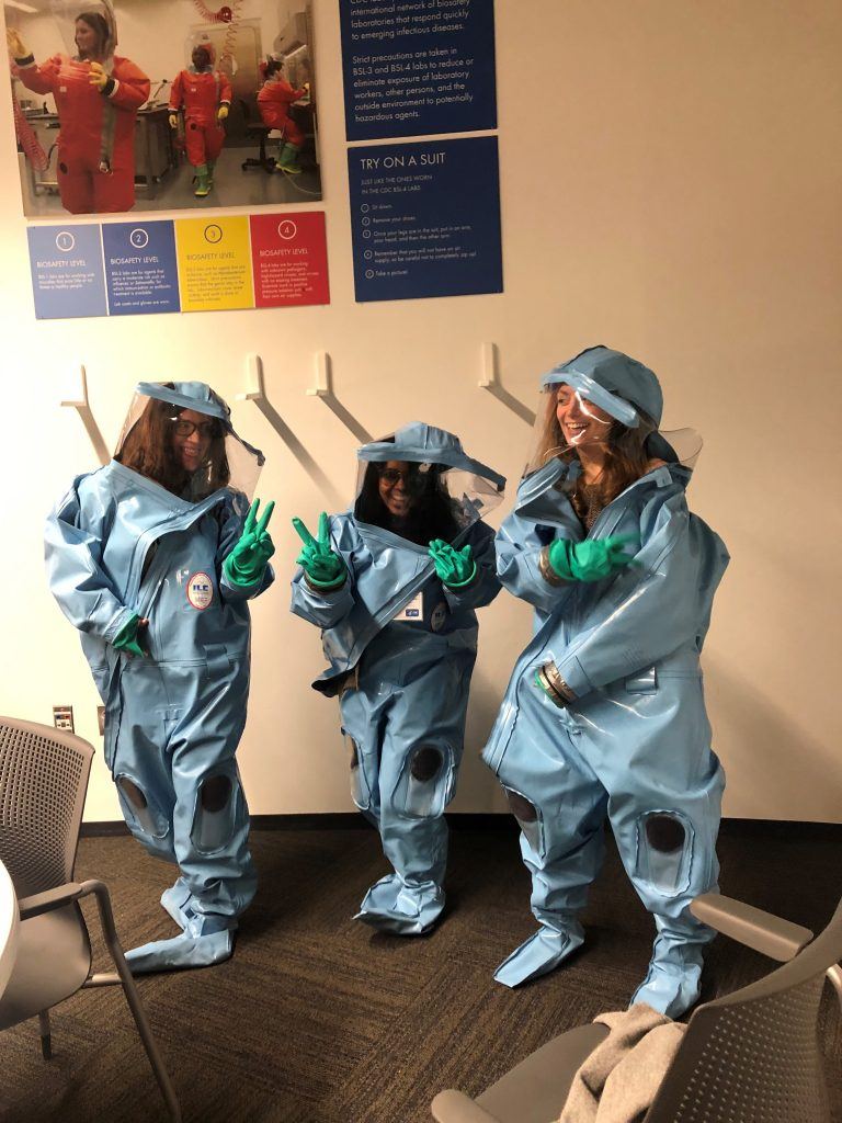 photo of students posing in protective body suits and gloves