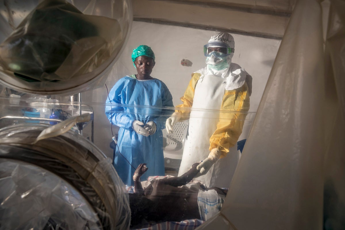 A doctor and medical worker care for an Ebola patient