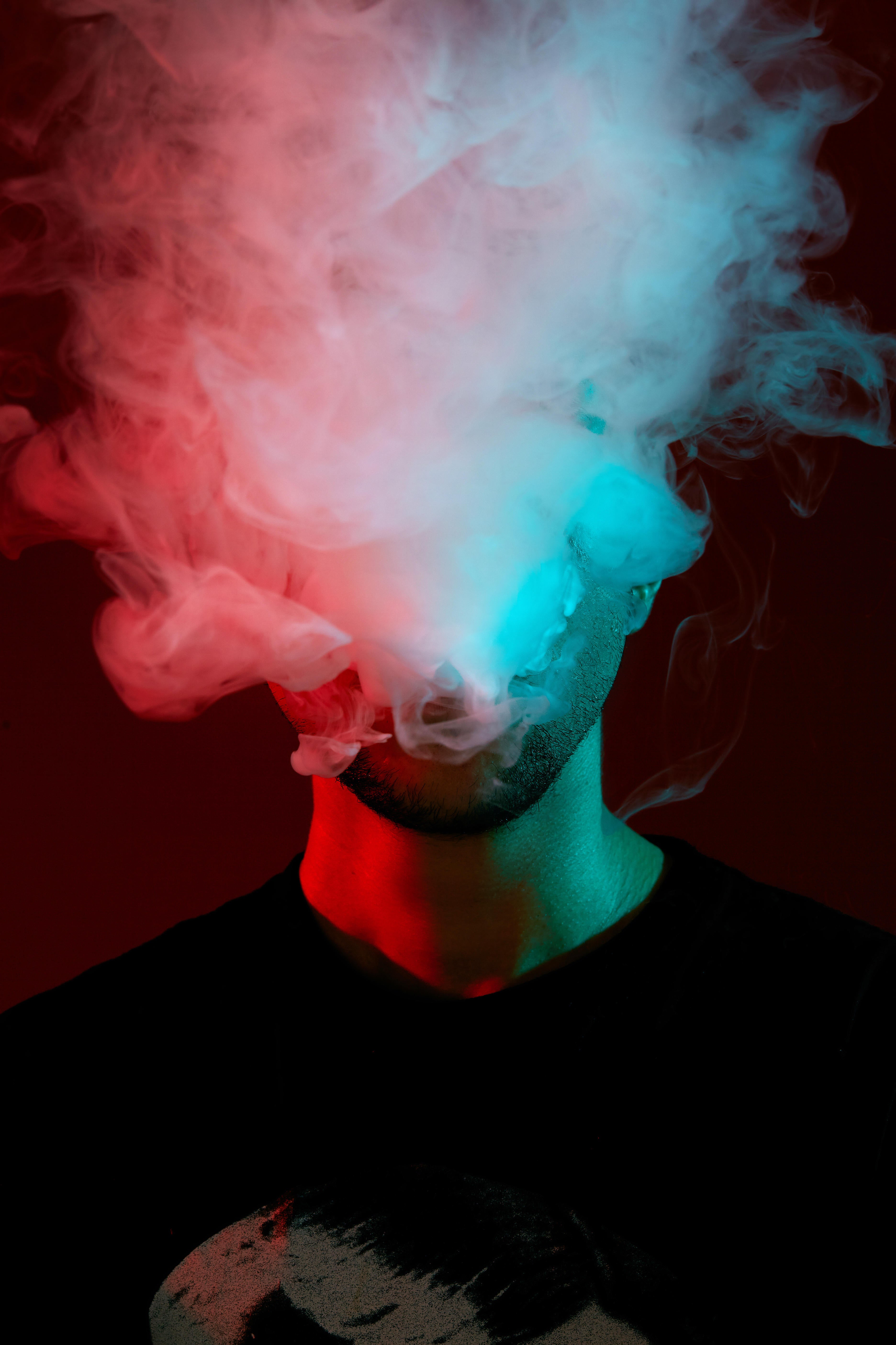 Man blows smoke, uses a vaping device
