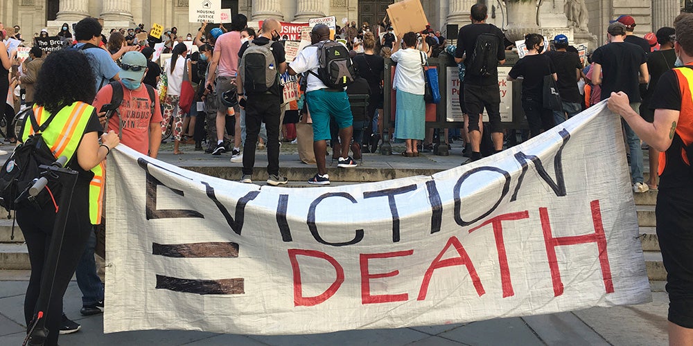 Photo of protesters holding sign that reads: "EVICTION = DEATH"