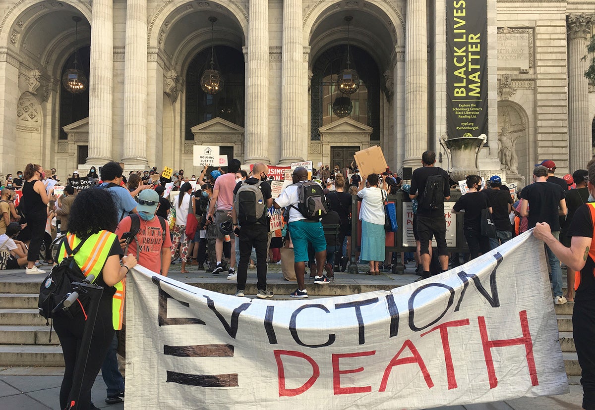 Photo of protesters holding sign that reads: "EVICTION = DEATH"