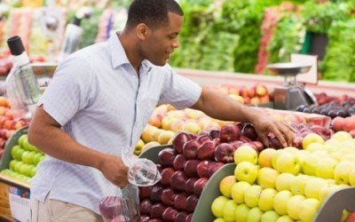 Man chooses apple in grocery store for eating healthy release