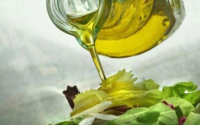 Olive oil pouring over a salad