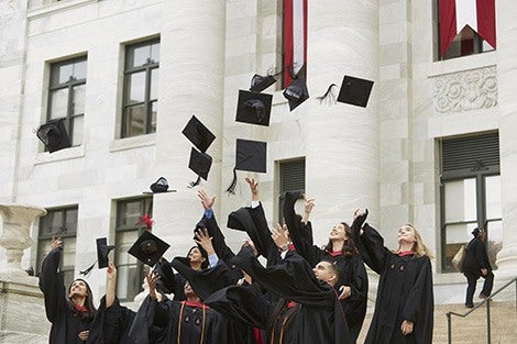 Students throw their caps in the air after convocation 2018