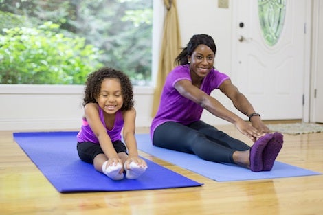 A mother and young daughter exercising together