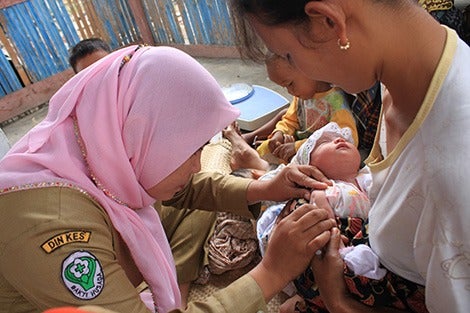 Health worker vaccinates baby