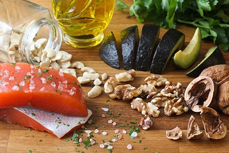 Salmon, avocado, nuts, and healthy oils on a board