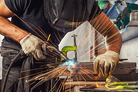 A man welding with a mask on.