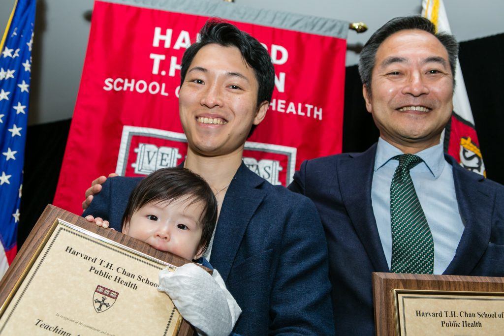 Father and baby with award