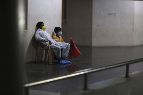 An Indian patient and his attendant wait at a coronavirus help desk at the Government Gandhi Hospital in Hyderabad, India, Sunday, March 15, 2020.