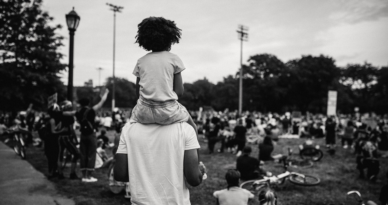 Black and white photo of young girl on her father's shoulders at a Black Lives Matter protest in Washington D.C.