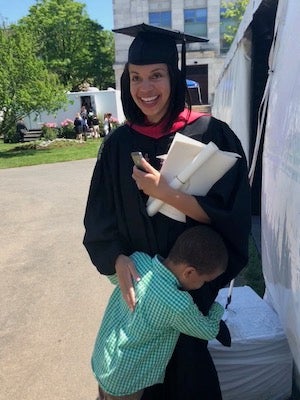 Elizabeth Perry at her 2018 Harvard Chan School graduation, hugging her young son