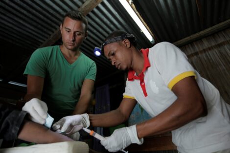 Christopher Golden assists a local Malagasy physician in drawing blood at a health clinic in northeastern Madagascar as part of his long-term planetary health research.