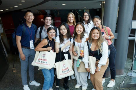 Big group of new Harvard Chan School students with branded totes