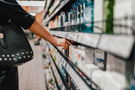 Woman choosing personal care product in a supermarket