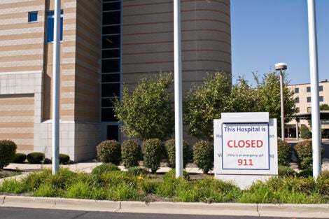 Photo of a hospital building with a sign in front saying that it is closed.