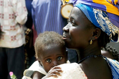 Kokemnoure, Burkina Faso - february 24, 2007: A mom in village Kokemnoure smiles into the distance with her young baby looking over her shoulder.