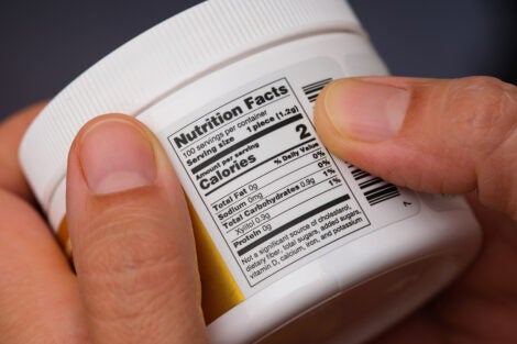 Hands holding a plastic jar with nutrition label displayed. It contains xylitol.