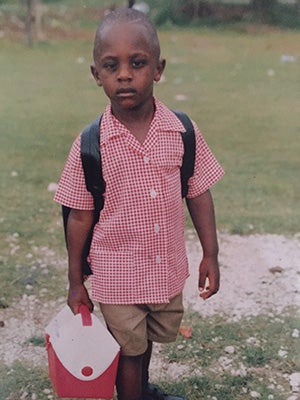 James Frater as a schoolboy in Jamaica, with backpack and lunchbox