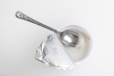 Top view of open yogurt container with spoon
