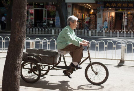 BEIJING, CHINA - MAY 12, 2013: Old woman on bicycle CHINA