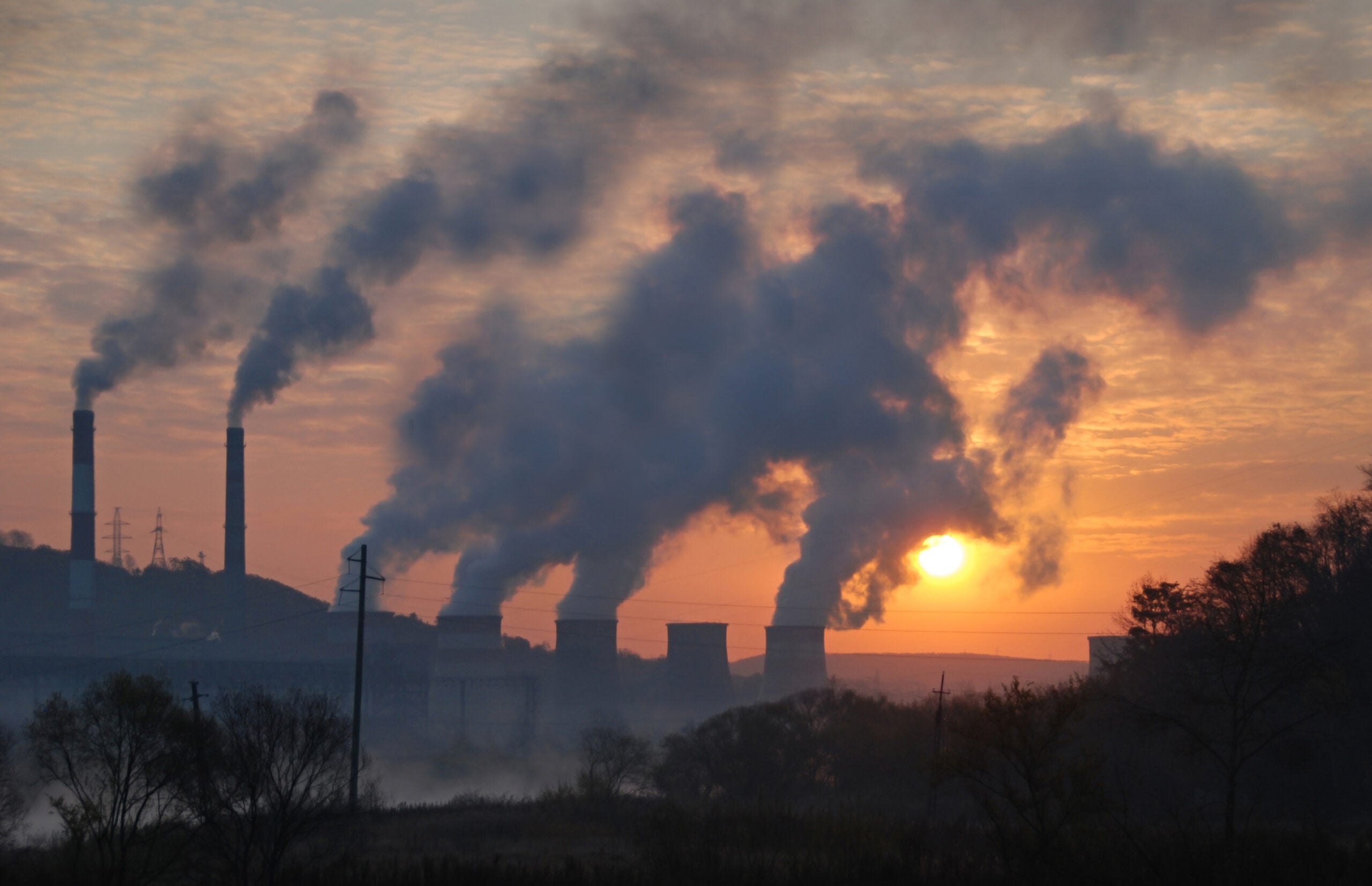 Smoke stacks in front of a setting sun