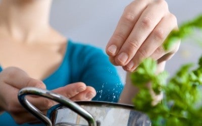 Woman adding salt to pot