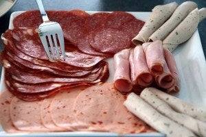 A plate of red and processed meats, including salami and ham