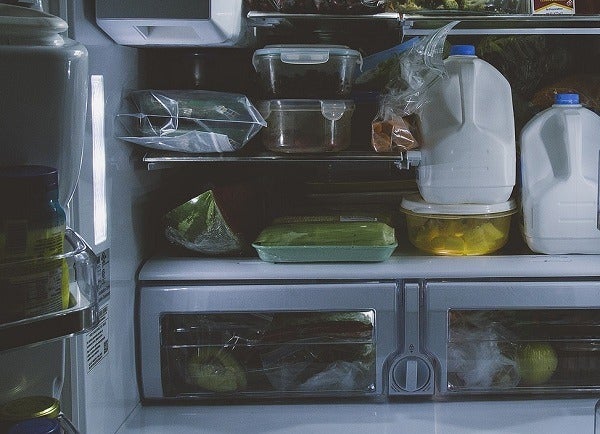 Full refrigerator with bottles of milk, and containers of food