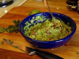 bowl of guacamole on a cutting board